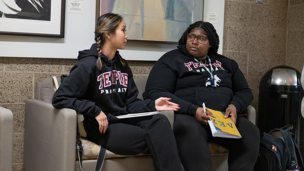 Students talking in hallway chairs