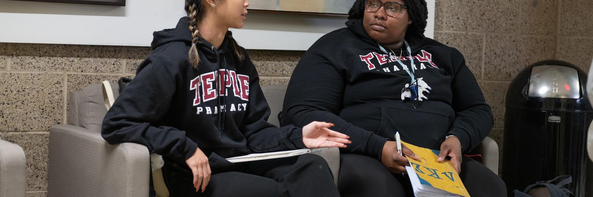Students talking in hallway chairs