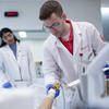A pharmacist with a patient in a hospital bed