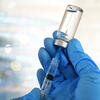 gloved hand with a syringe
