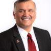 headshot of Dean Madhavan in a red tie